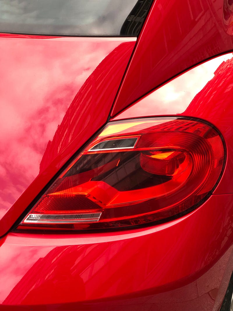 Brightly colored red car on the road